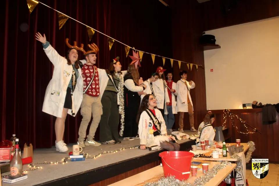Het praesidium staat op een podium met slingers tijdens een cantus